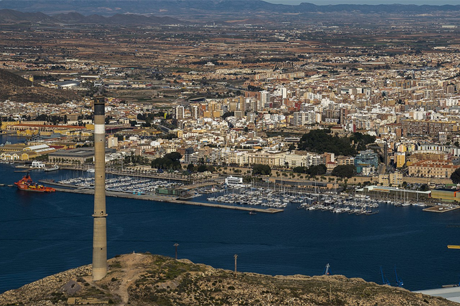 Chimenea de la Fundición Santa Lucía, a la izquierda de la imagen. Al fondo, vista general de Cartagena