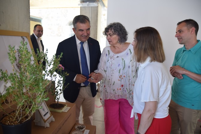 La investigadora María José Vicente y la rectora, Beatriz Miguel, muestran al consejero, Juan María Vázquez, una planta de jara de Cartagena y una reproducción artesanal en papel