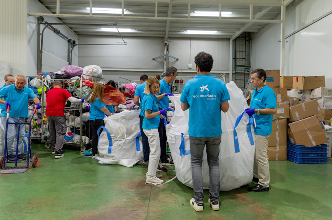Voluntarios convocados por CaixaBank recogen ropa usada