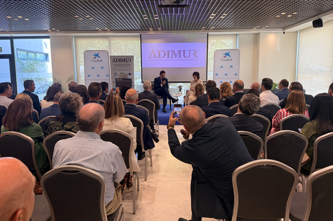 Antonio López y Cani Fernández, al fondo, conversan ante los directivos socios de Adimur