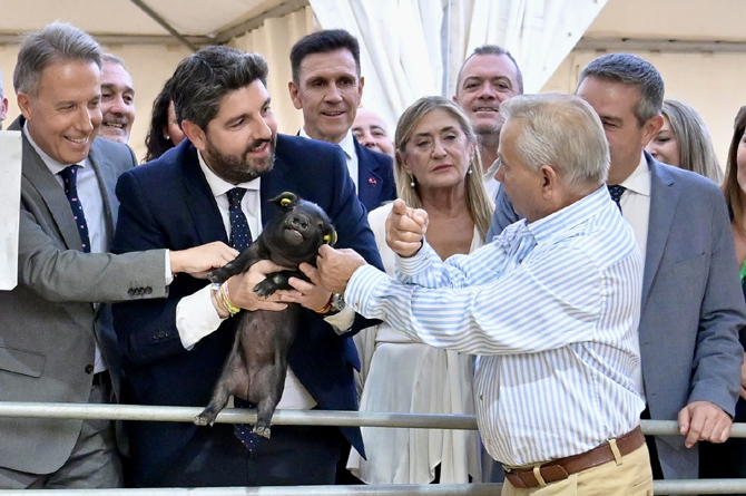 L&oacute;pez Miras coge un cochinillo en la inauguraci&oacute;n de Sepor