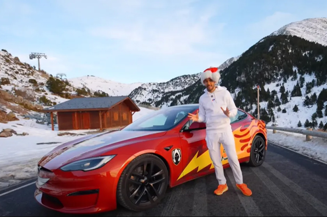 TheGrefg, en las monta&ntilde;as de Andorra, ante su coche, un Tesla tuneado como Rayo McQueen