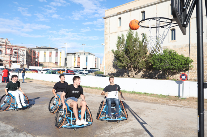 Alumnos de la UPCT tratan de jugar al baloncesto en silla de ruedas