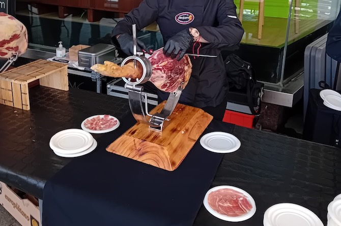 Profesional de ASOJAM cortando jamón en otro evento en la Región