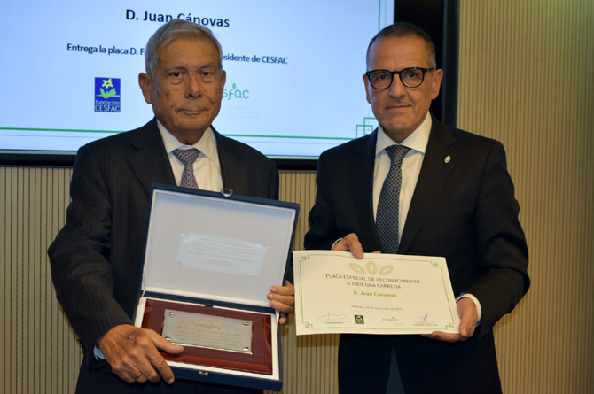 Juan Cánovas, a la izquierda, recoge la placa con el reconocimiento